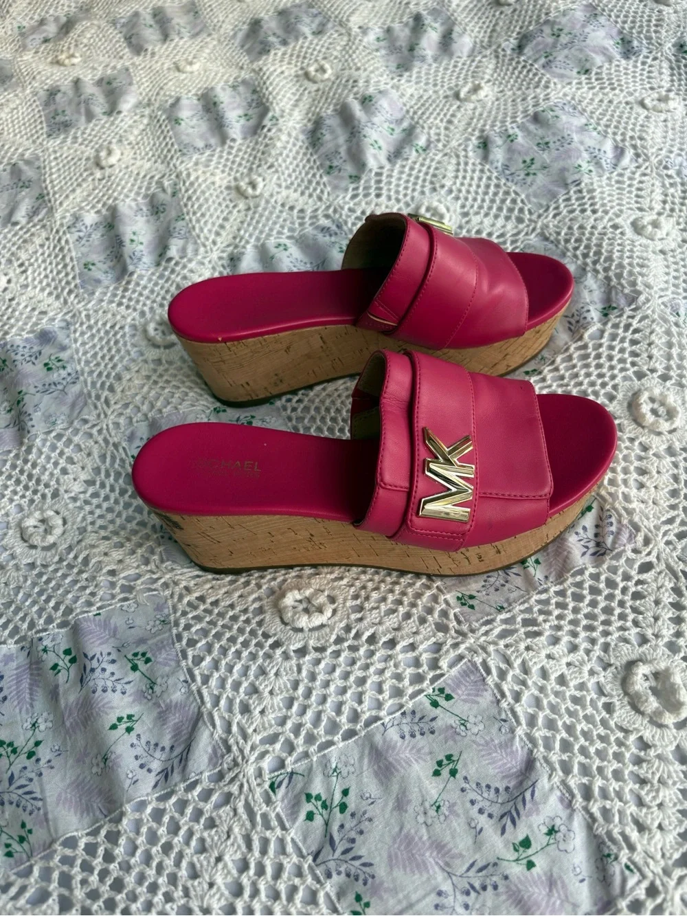 Michael Kors bright pink platform slide sandals with a cork wedge.